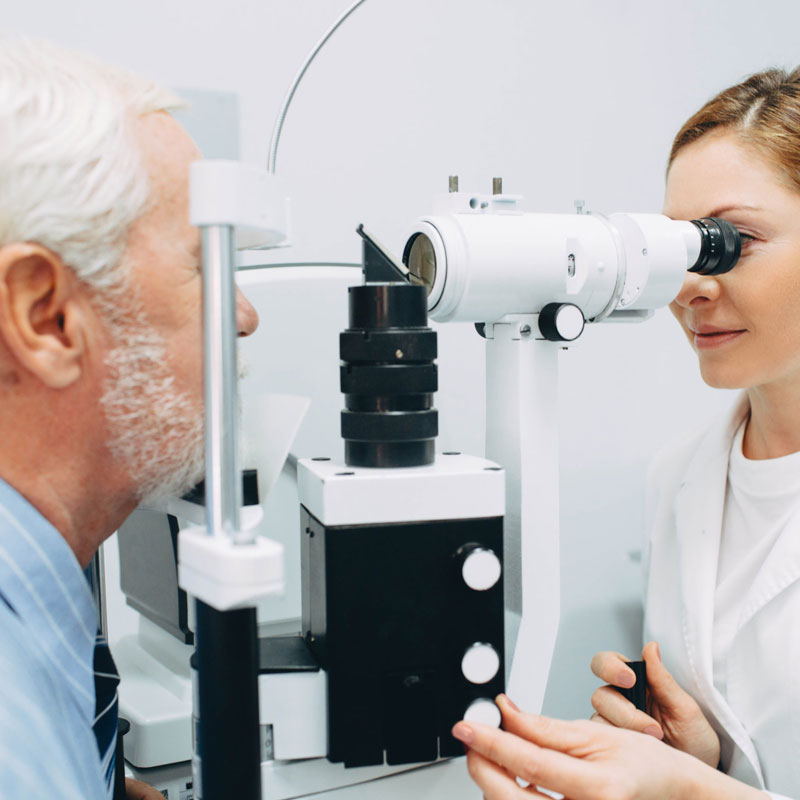 Old man taking his eye exam with her eye doctor