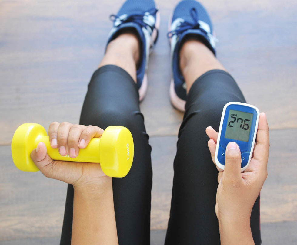 Woman holding a dumbell and oxygen meter